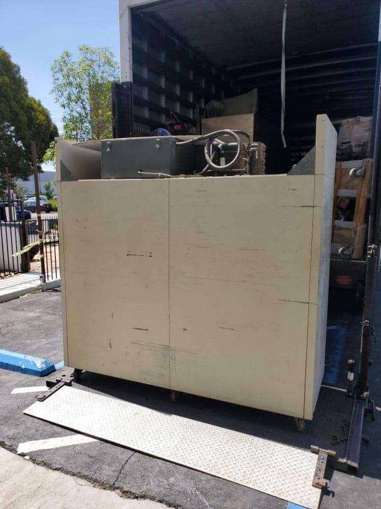 Large industrial equipment loaded in a truck, viewed from the rear entrance.